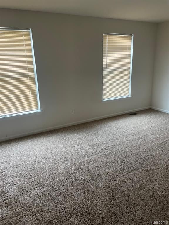 carpeted empty room with baseboards