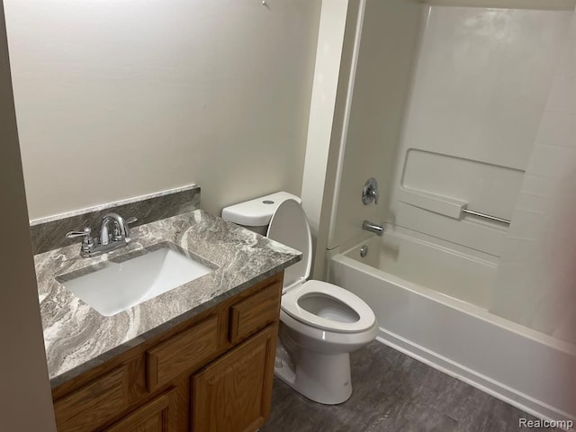 bathroom with shower / washtub combination, toilet, vanity, and wood finished floors