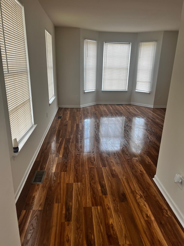 spare room featuring visible vents, wood finished floors, and baseboards