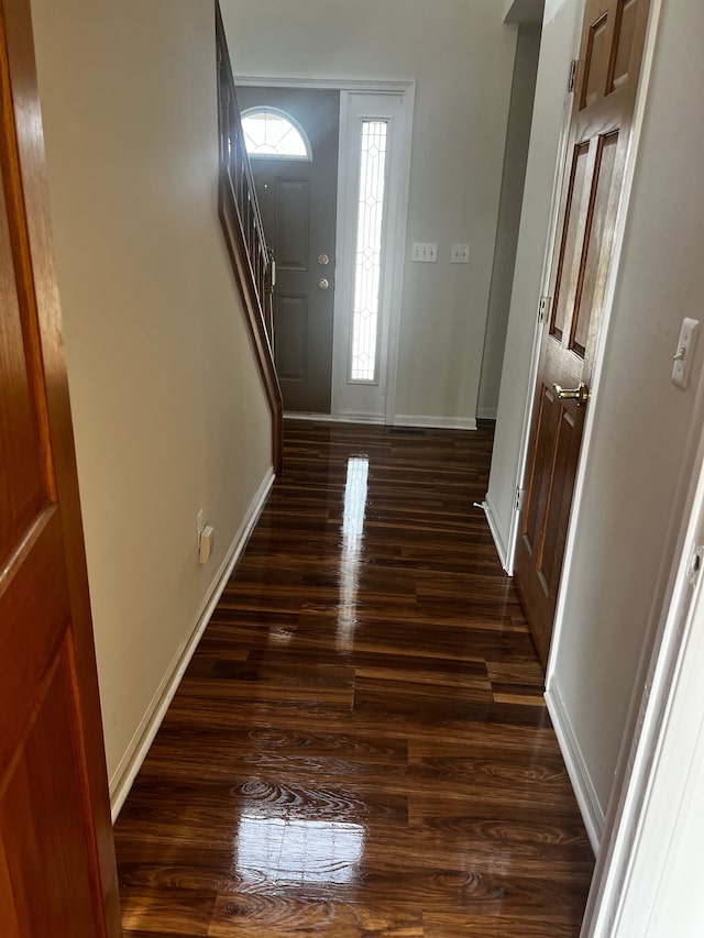 entryway with dark wood-type flooring and baseboards