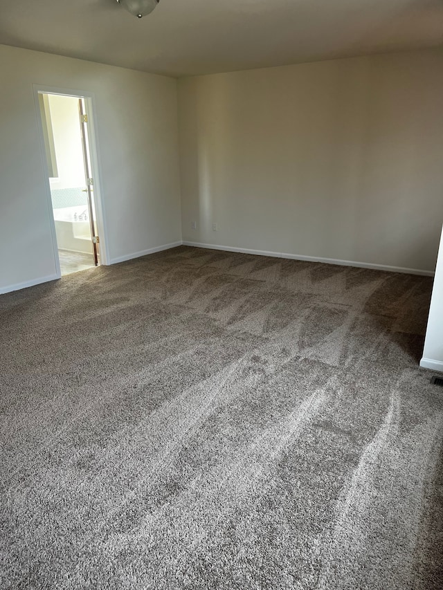 carpeted spare room featuring baseboards