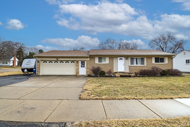 single story home with a front lawn, an attached garage, brick siding, and driveway