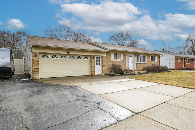 ranch-style home featuring concrete driveway, brick siding, a garage, and a front lawn