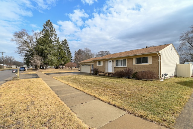 single story home featuring a front yard, a garage, brick siding, and driveway