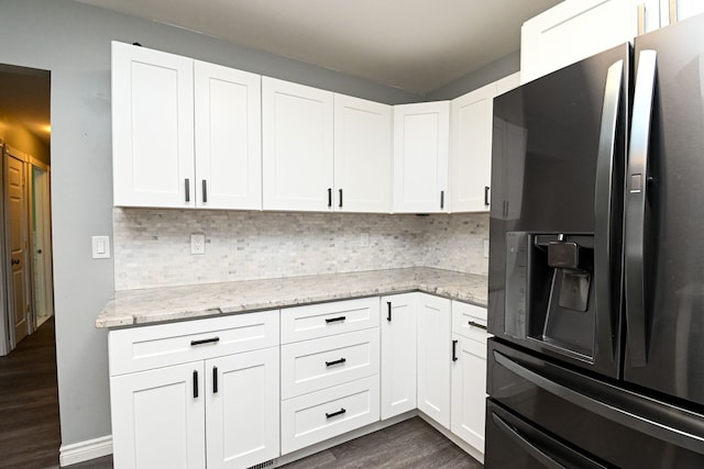 kitchen featuring backsplash, dark wood-style flooring, black refrigerator with ice dispenser, and white cabinetry