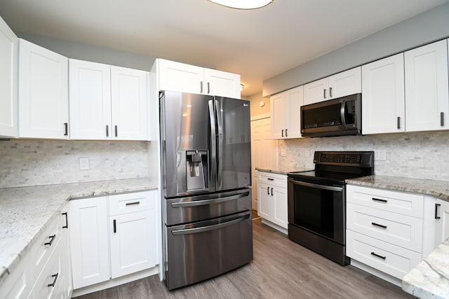 kitchen featuring decorative backsplash, wood finished floors, electric range, stainless steel fridge, and white cabinetry