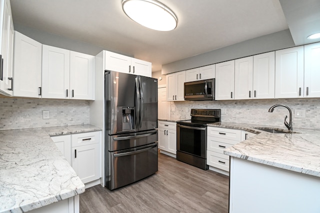 kitchen featuring light stone countertops, a sink, range with electric cooktop, stainless steel microwave, and fridge with ice dispenser