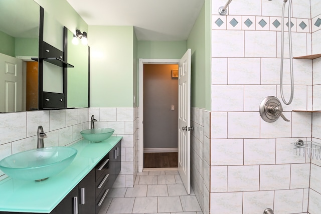 bathroom with double vanity, tile walls, and a sink