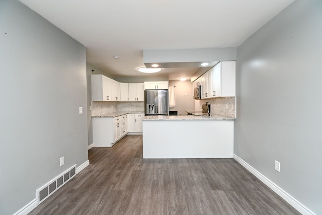 kitchen featuring stainless steel appliances, baseboards, visible vents, and a peninsula