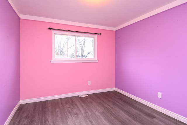 spare room featuring dark wood finished floors and baseboards