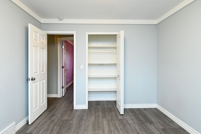 unfurnished bedroom featuring visible vents, dark wood-type flooring, and baseboards