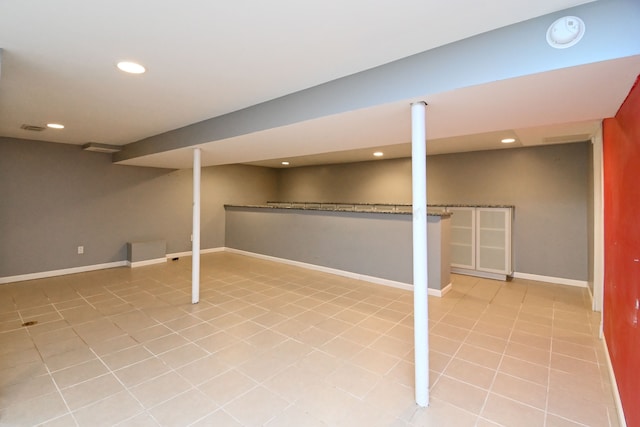 finished below grade area with tile patterned flooring, recessed lighting, and baseboards