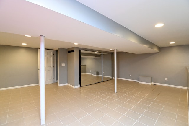 finished basement featuring light tile patterned floors, recessed lighting, and baseboards