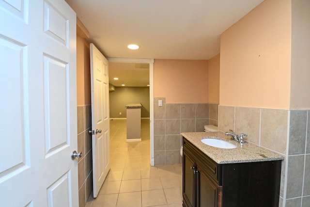 bathroom with vanity, a wainscoted wall, recessed lighting, tile walls, and tile patterned floors