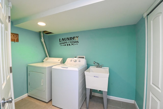 laundry area featuring washer and dryer, baseboards, laundry area, and a sink