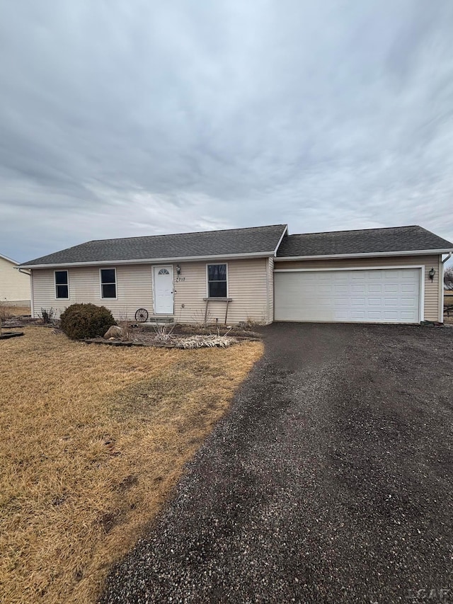 single story home featuring aphalt driveway, a garage, and a front yard