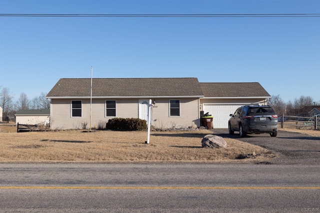 single story home with driveway, fence, roof with shingles, and a garage
