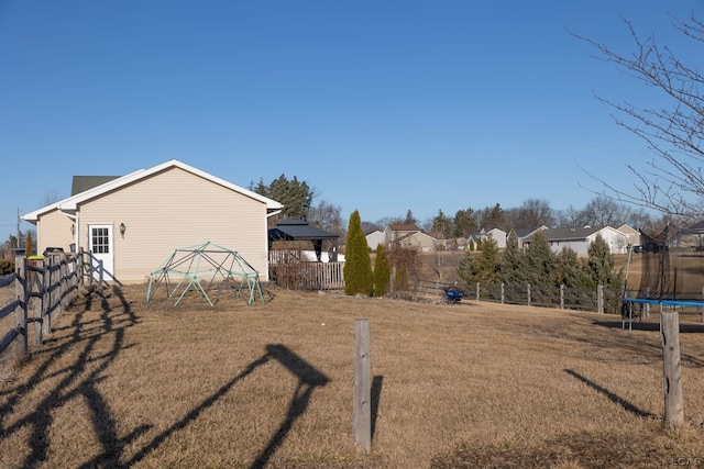 view of yard featuring a fenced backyard, a gazebo, and a trampoline