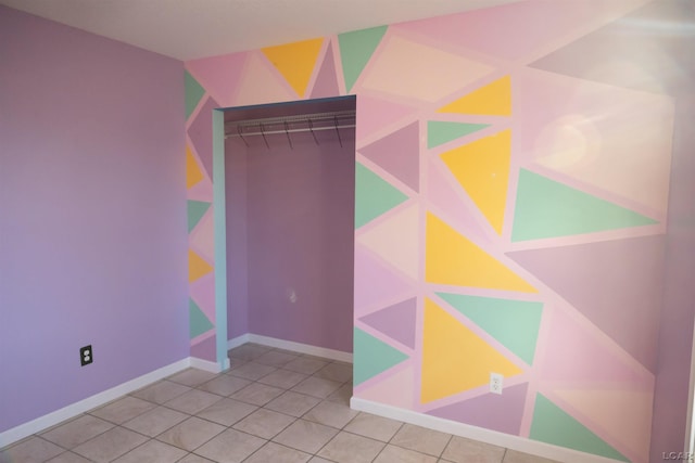 unfurnished bedroom with baseboards and tile patterned flooring