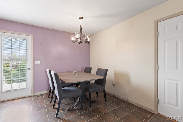 dining space featuring visible vents, baseboards, and an inviting chandelier