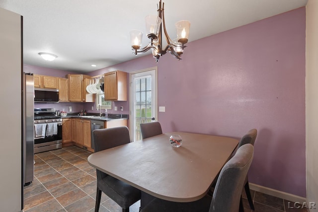 dining room with stone finish flooring, baseboards, and an inviting chandelier