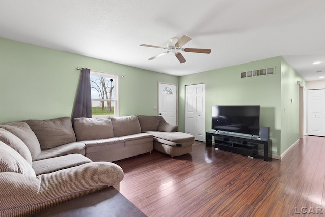 living area with wood finished floors, visible vents, a ceiling fan, and baseboards