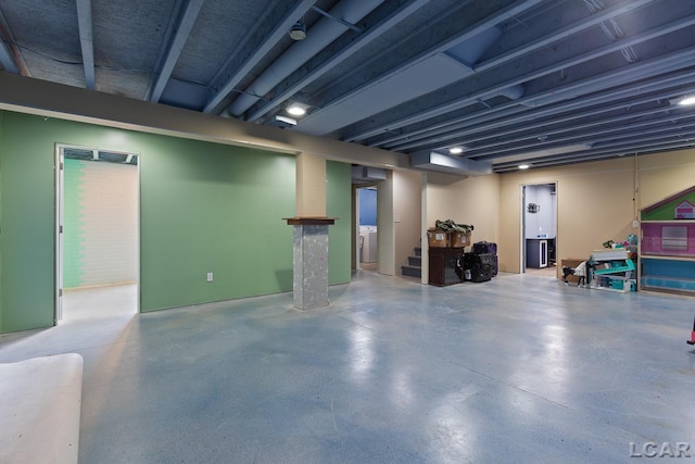 finished below grade area featuring stairs and washer / clothes dryer