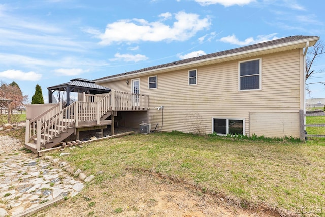 rear view of house featuring a gazebo, a lawn, central AC, and stairway