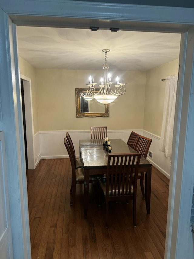 dining area featuring a chandelier, visible vents, baseboards, and dark wood-style flooring