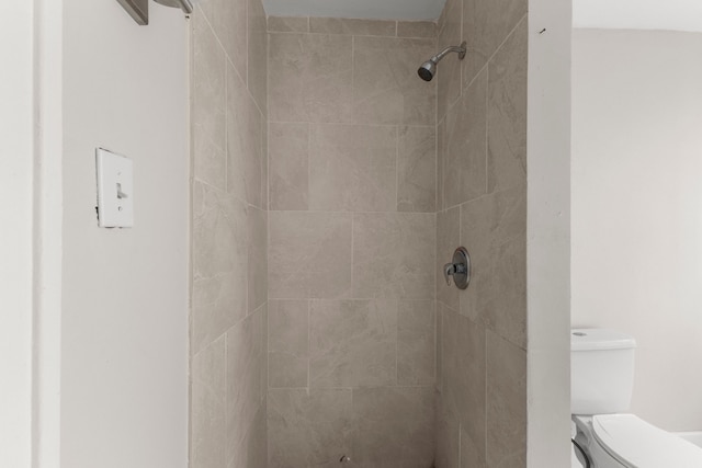 bathroom with toilet and a tile shower