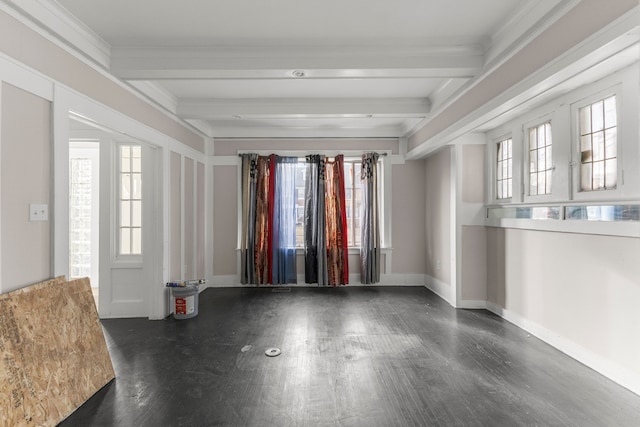 spare room featuring plenty of natural light, beamed ceiling, baseboards, and wood finished floors