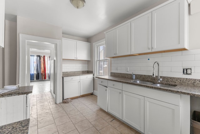 kitchen featuring plenty of natural light, white cabinetry, and a sink