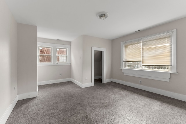 carpeted empty room with visible vents and baseboards