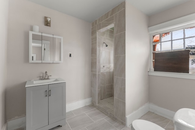 bathroom with baseboards, vanity, toilet, and walk in shower