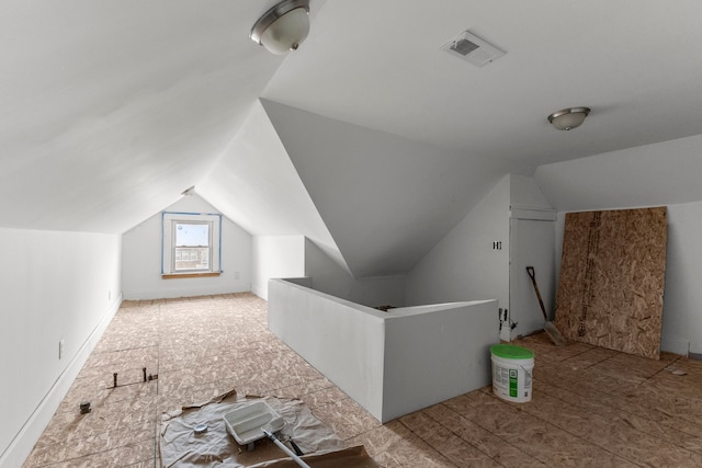 additional living space featuring lofted ceiling and visible vents