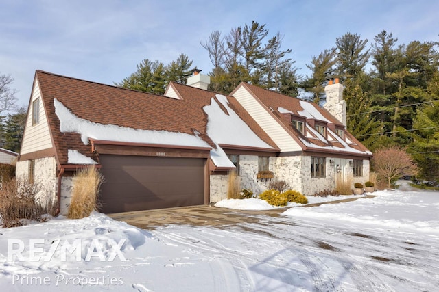 view of front of property with stone siding, a chimney, and an attached garage