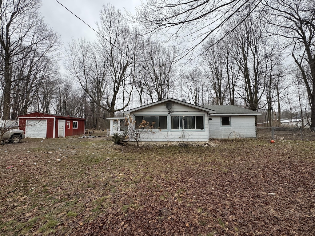 view of front of house with a garage and an outbuilding