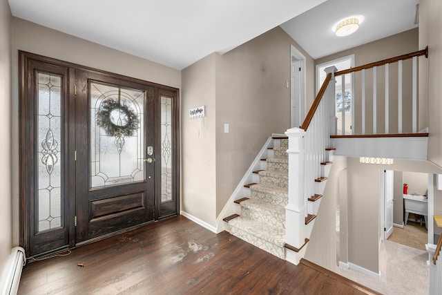 entryway featuring stairway, baseboards, baseboard heating, and wood finished floors