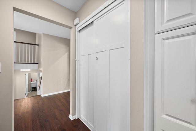 corridor featuring dark wood-style flooring and baseboards