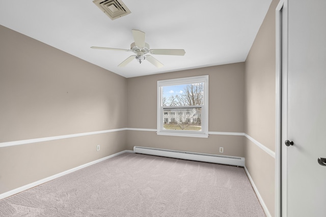 empty room featuring carpet floors, baseboards, visible vents, and baseboard heating