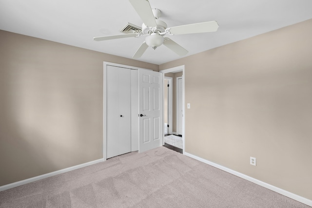 unfurnished bedroom featuring carpet, visible vents, baseboards, and a closet