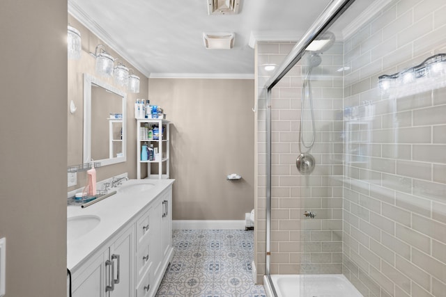 bathroom with double vanity, ornamental molding, a sink, a shower stall, and baseboards