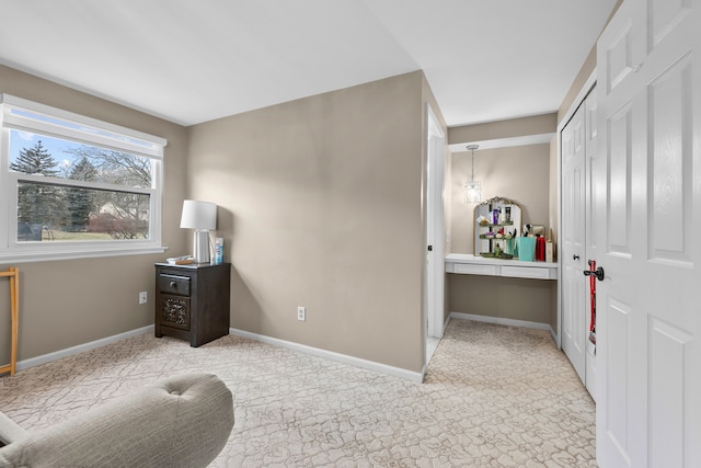 carpeted bedroom with a closet and baseboards