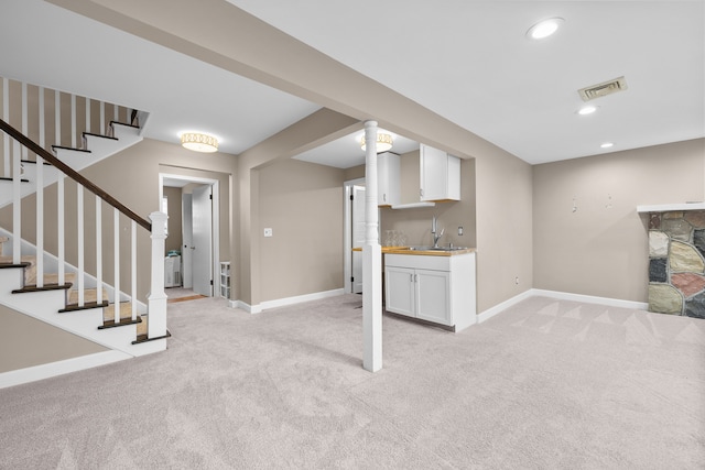 interior space with light carpet, visible vents, and baseboards