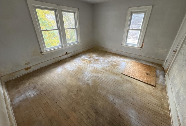 spare room with plenty of natural light and hardwood / wood-style floors