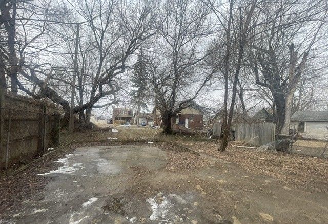 view of yard with driveway and fence