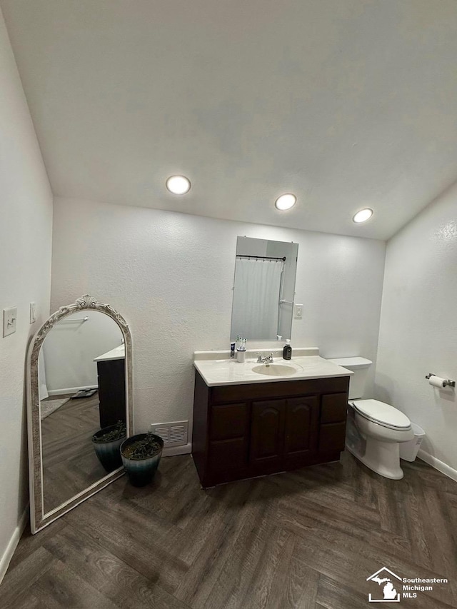 full bath with toilet, visible vents, vanity, baseboards, and parquet floors