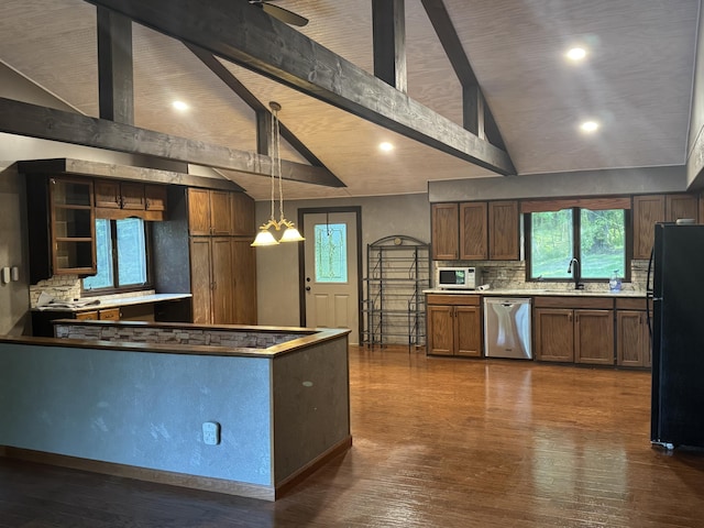 19084 200th Ave, Tustin, MI 49688 - kitchen with stainless steel dishwasher, freestanding refrigerator, white microwave, tasteful backsplash, and dark wood-style floors