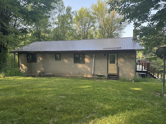 19084 200th Ave, Tustin, MI 49688 - view of front of house featuring a front lawn, a chimney, a metal roof, and entry steps