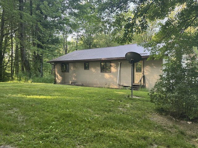19084 200th Ave, Tustin, MI 49688 - rear view of house with a lawn and a metal roof